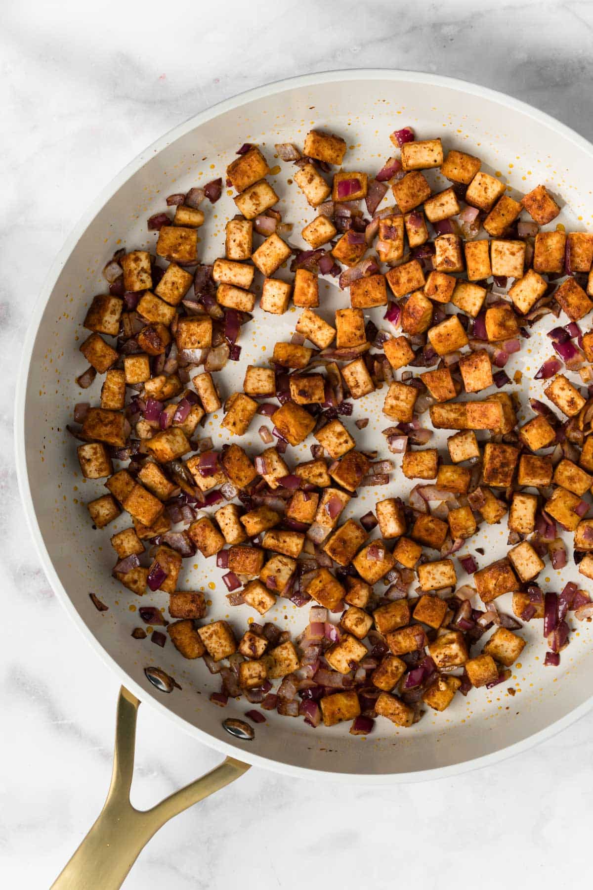 overhead view of taco-seasoned tofu cooking in a skillet.