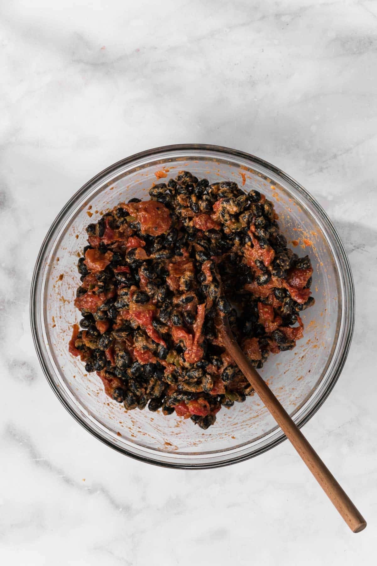 overhead view of a black bean and tomato enchilada filling in a glass bowl.