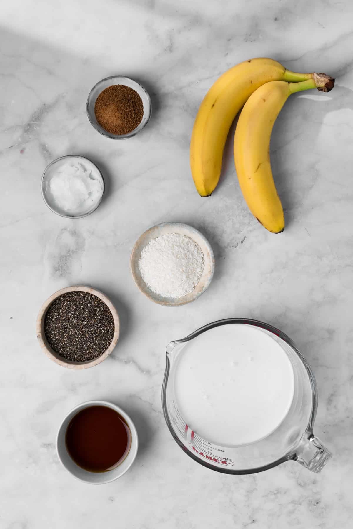 Overhead view of the ingredients for a coconut chia pudding in individual bowls.