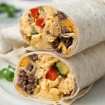 side view of a halved breakfast burrito on a plate.