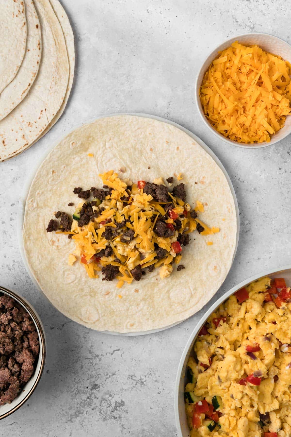 overhead view of a breakfast burrito being assembled.