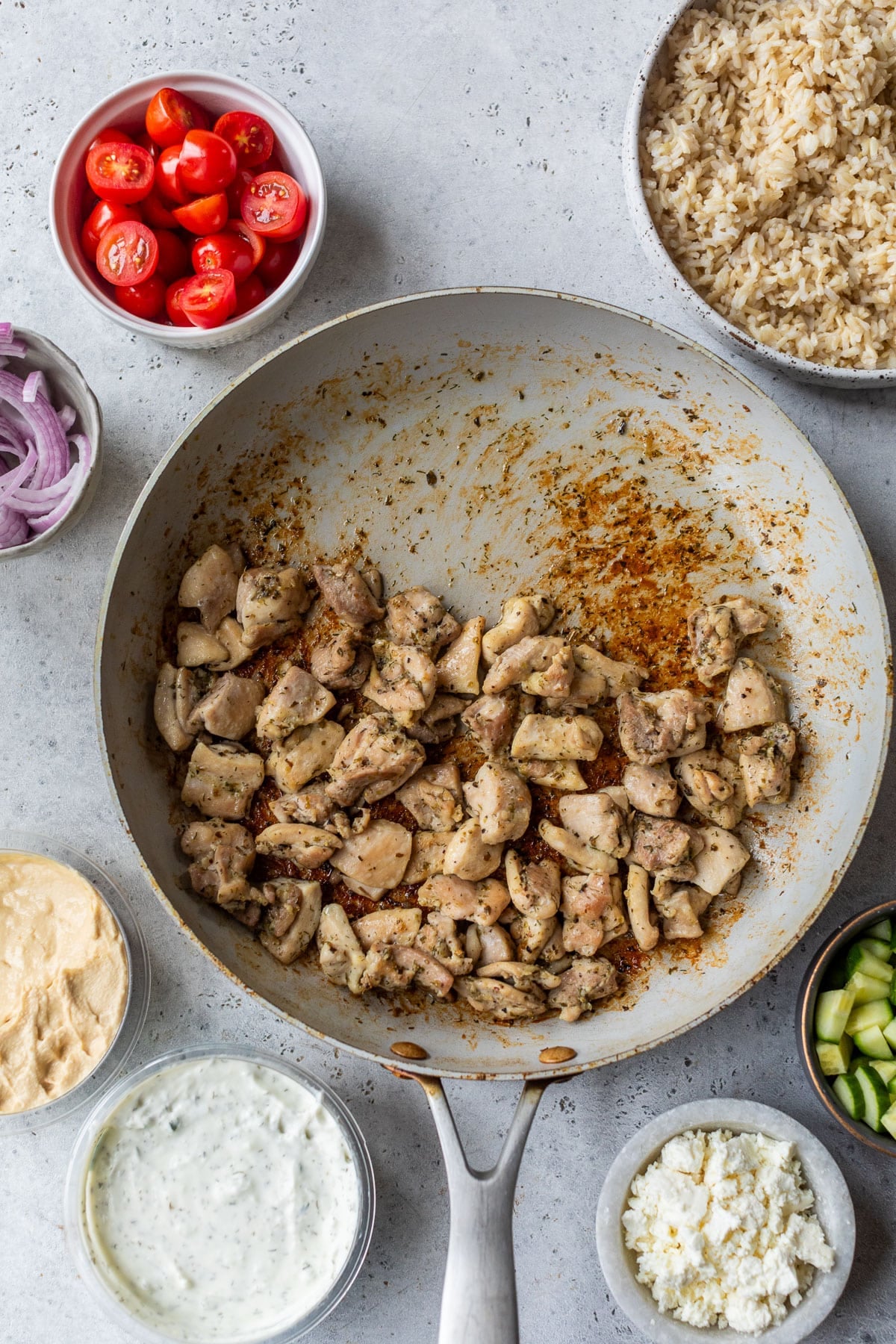 overhead view of the ingredients for Mediterranean Chicken Bowls in individual bowls.