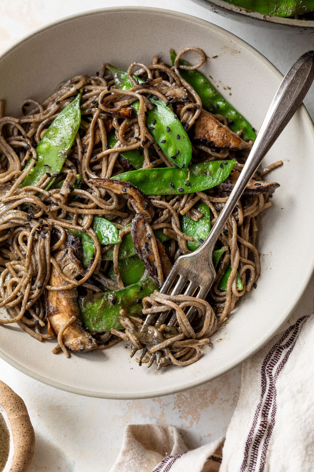 overhead view of a fork in a bowl of Black Sesame Tahini Noodles.
