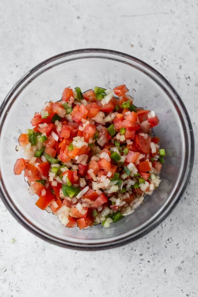 glass bowl filled with diced tomato, onion and green bell pepper