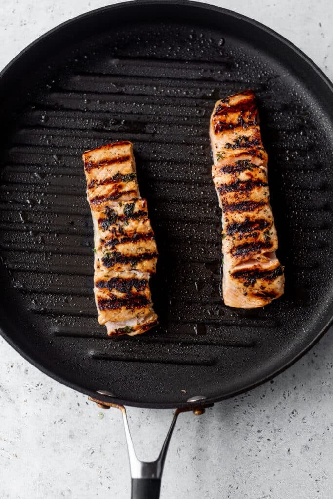 two pieces of grilled salmon in a grill pan