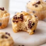 side view of a greek yogurt muffin with a bite taken out of it with more muffins in the background.