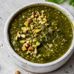 overhead view of a small bowl of pistachio pesto topped with chopped pistachios.