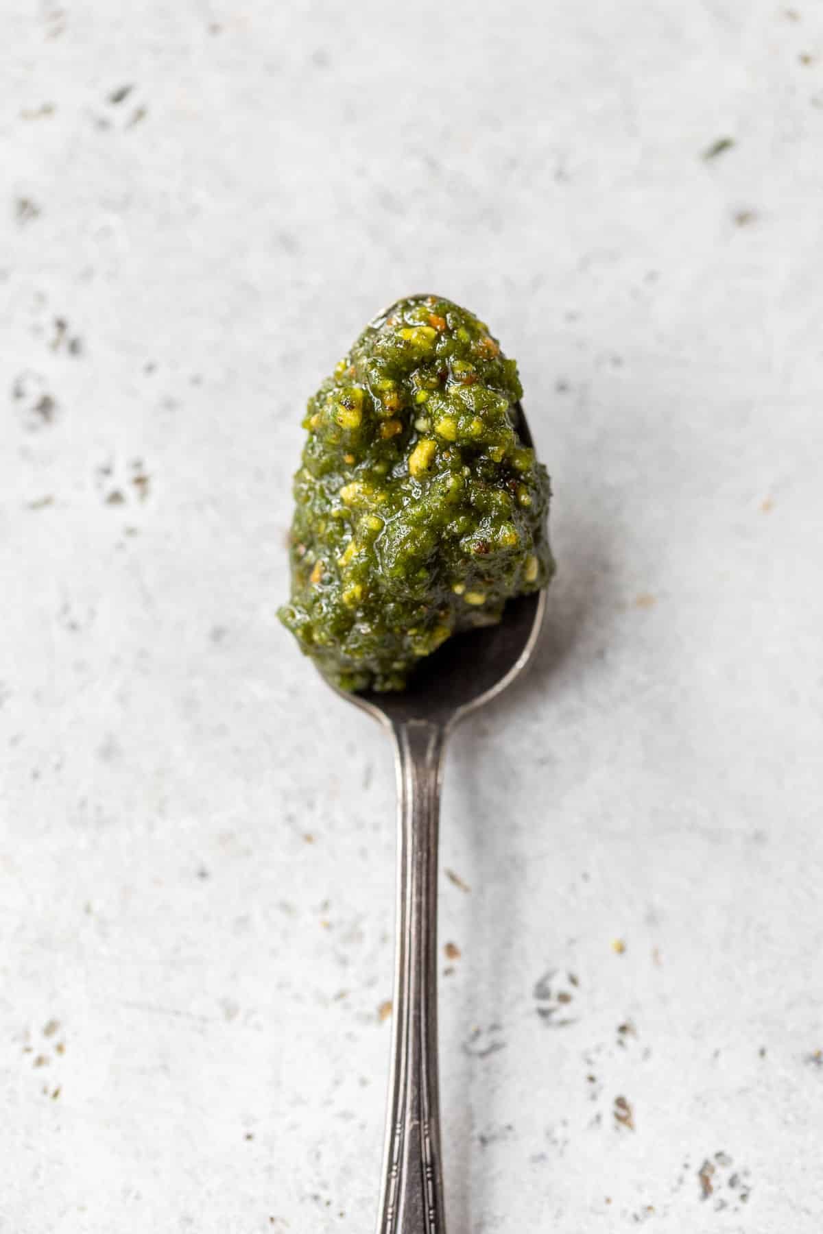 overhead view of a spoonful of pistachio pesto.
