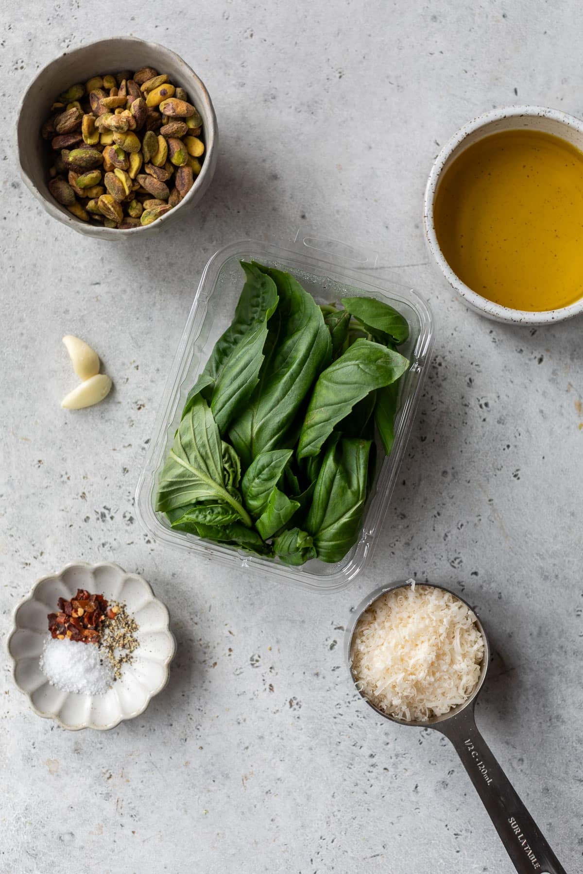 overhead view of the ingredients for pistachio pesto in individual bowls.