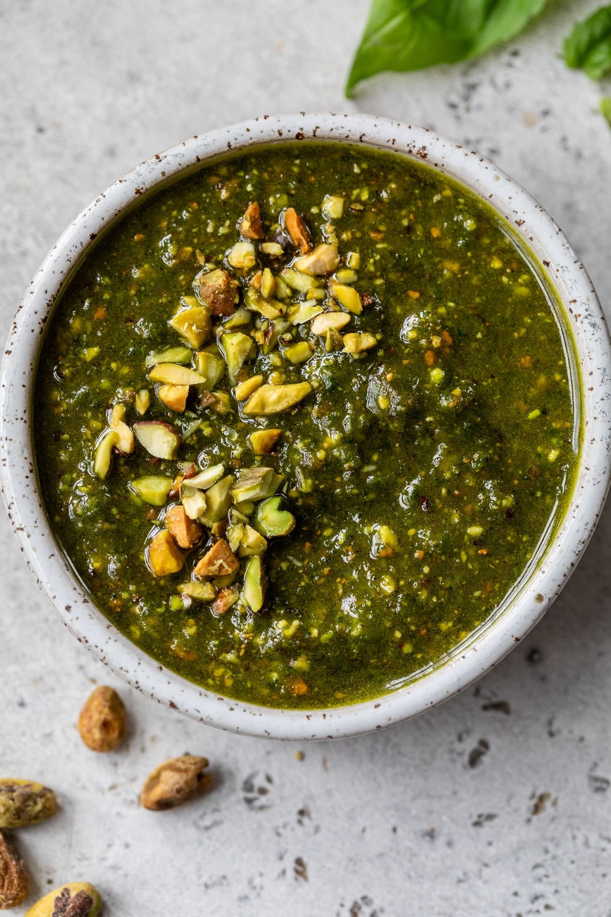 overhead view of a small bowl of pistachio pesto topped with chopped pistachios.