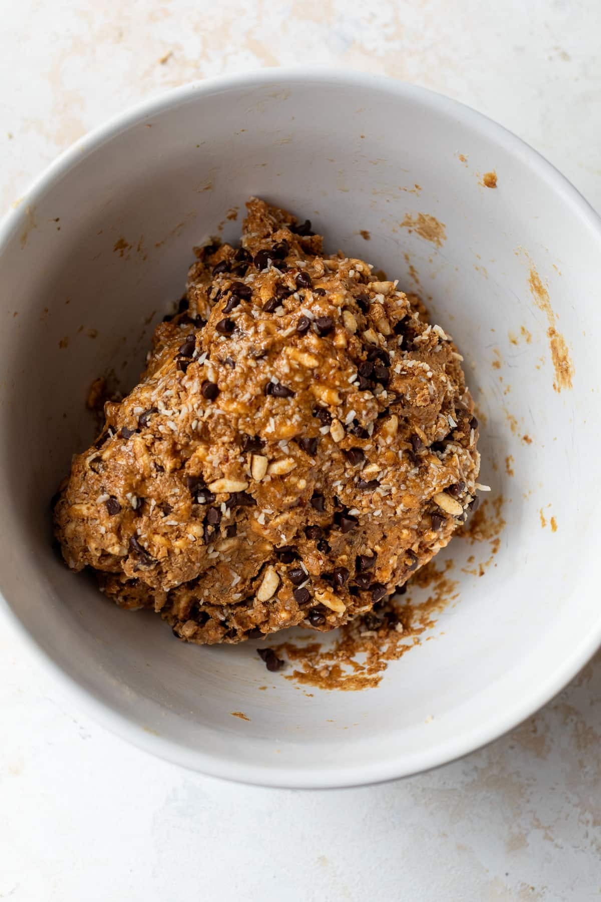 overhead view of the batter for puffed rice protein bars in a white bowl.