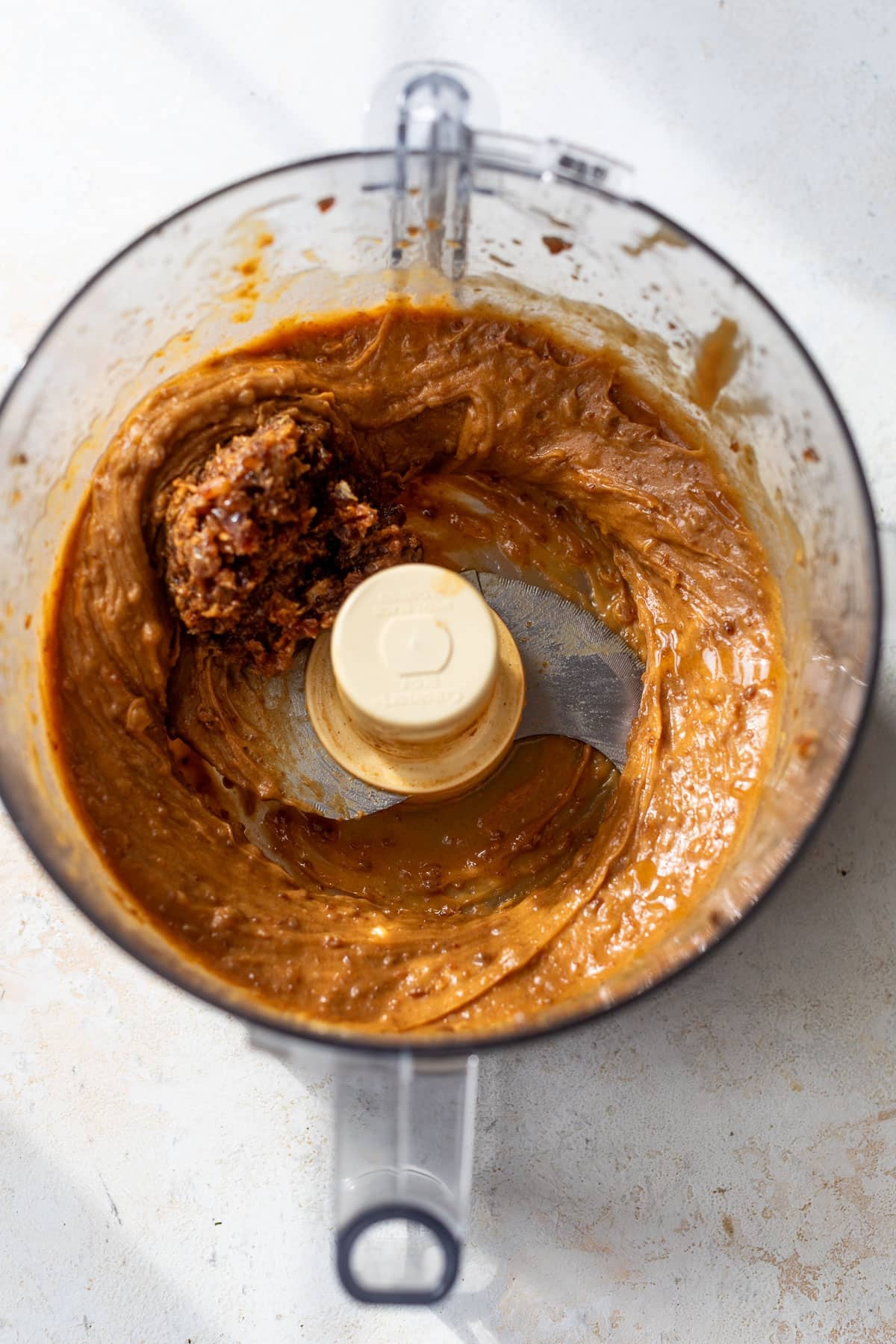 overhead view of the wet mixture for puffed rice protein bars in a food processor.