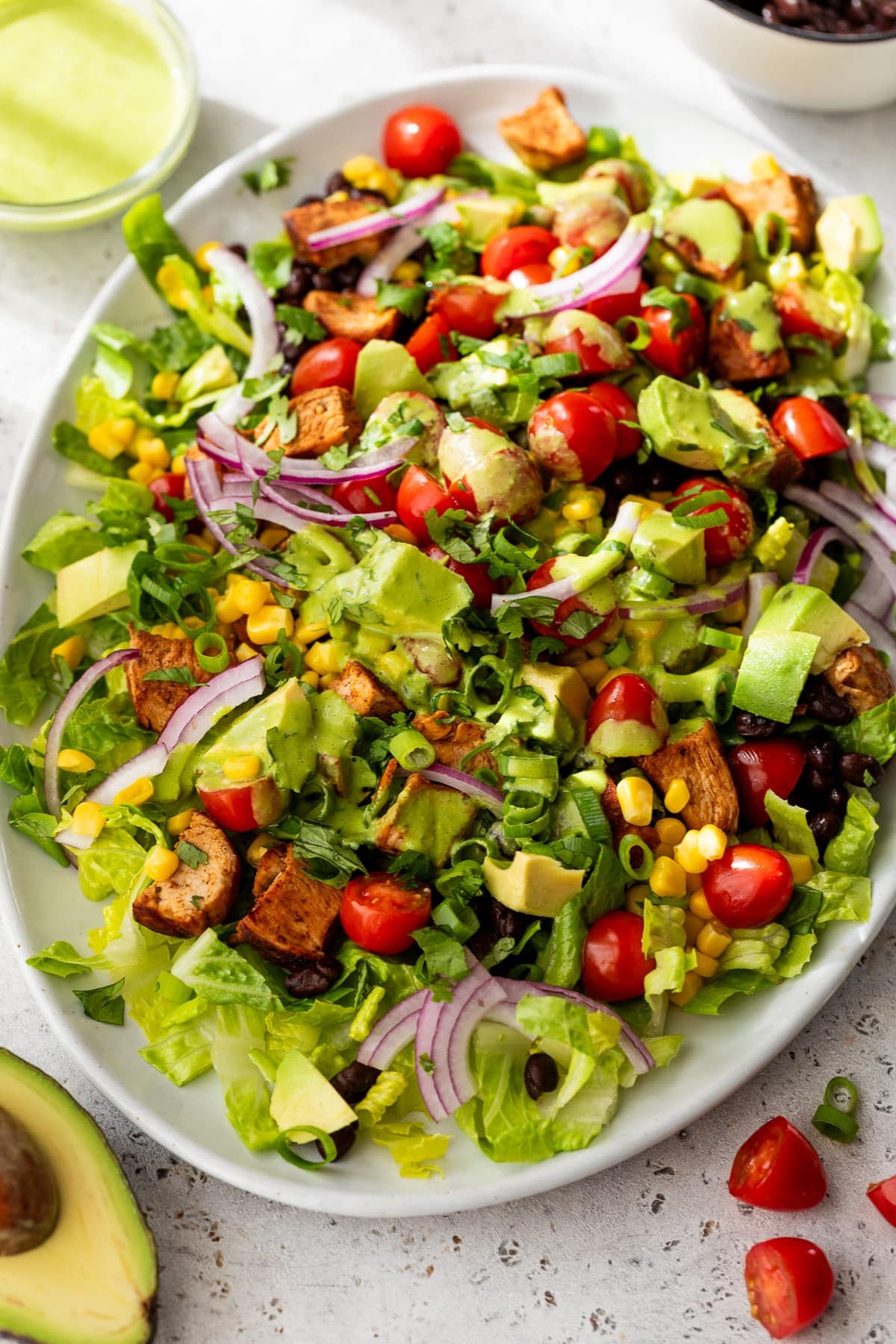 side view of a chicken taco salad on a white serving platter.