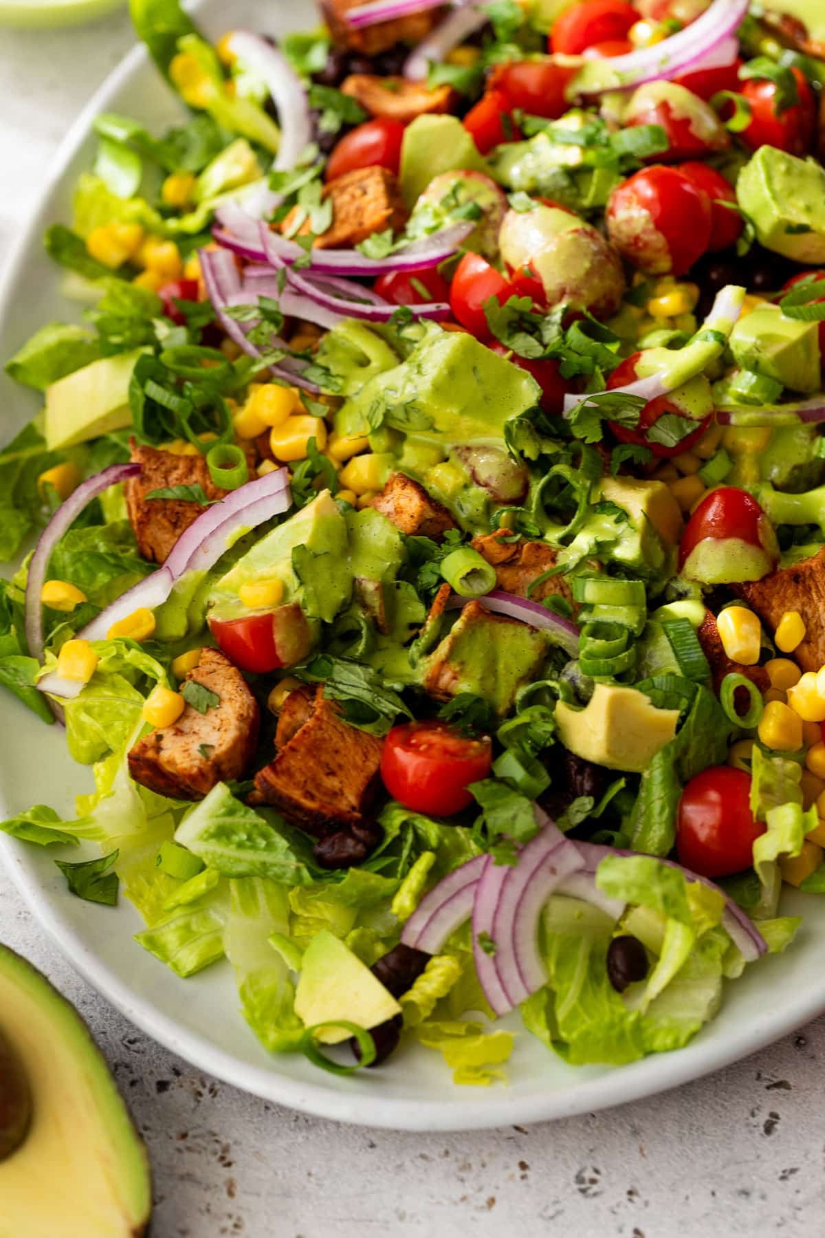side view of a chicken taco salad on a white serving platter.