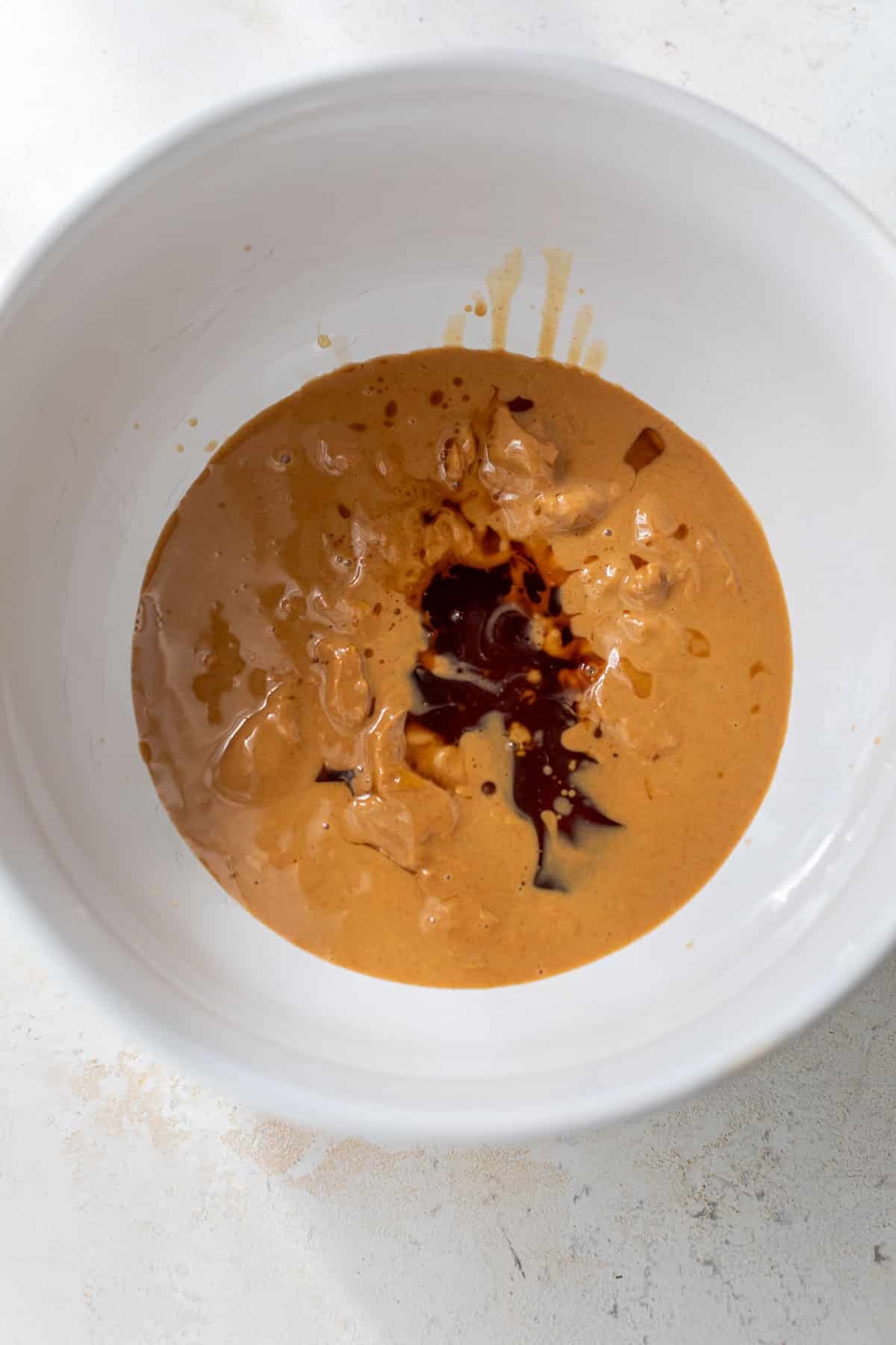 overhead view of the wet ingredients for Healthy Peanut Butter Rice Crispy Treats in a white bowl.