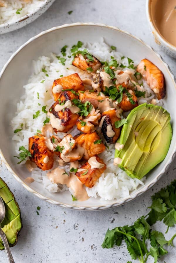 overhead view of a honey chipotle salmon bowl topped with avocado and chipotle mayo.