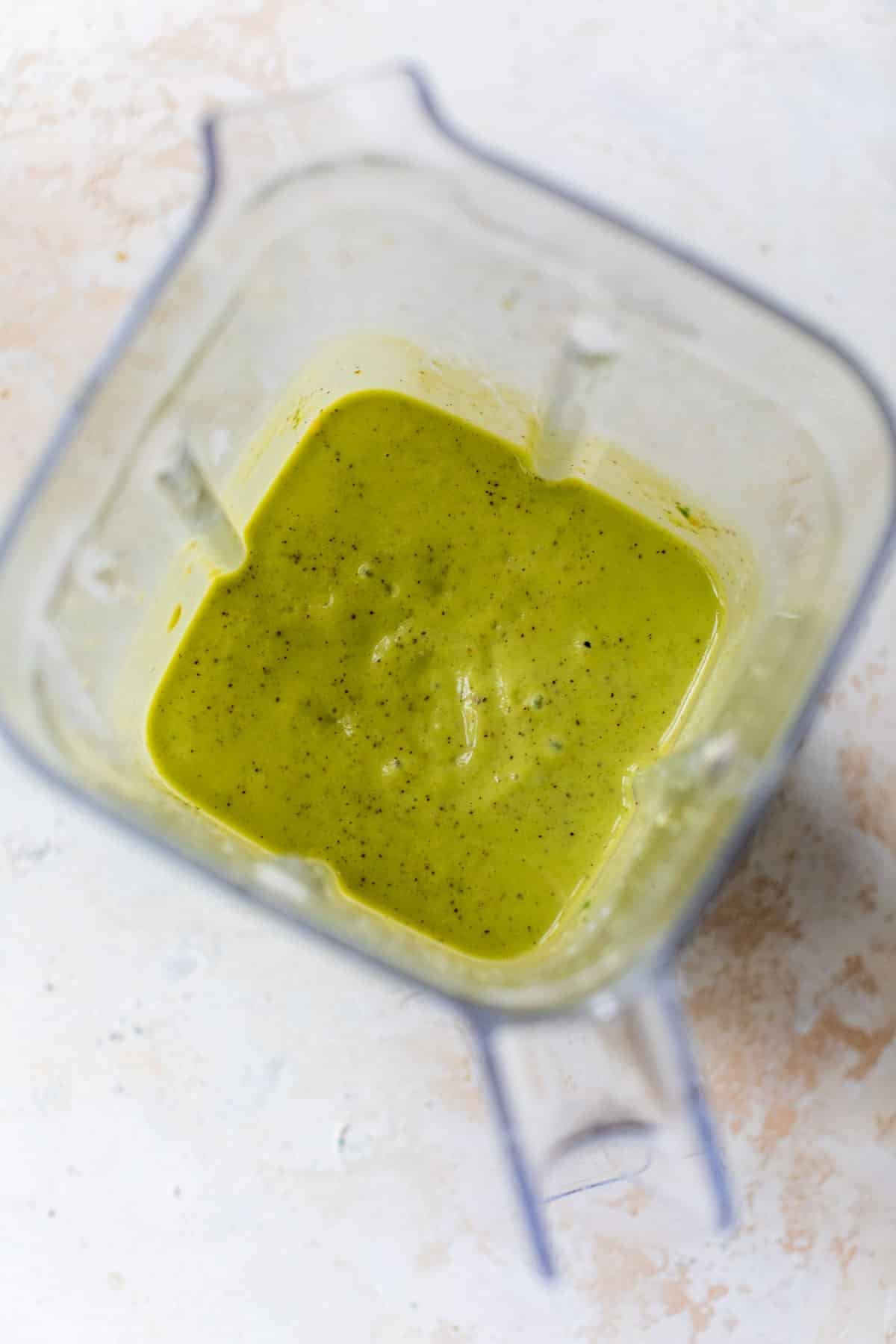 overhead view of a blended green kiwi smoothie in a large blender.