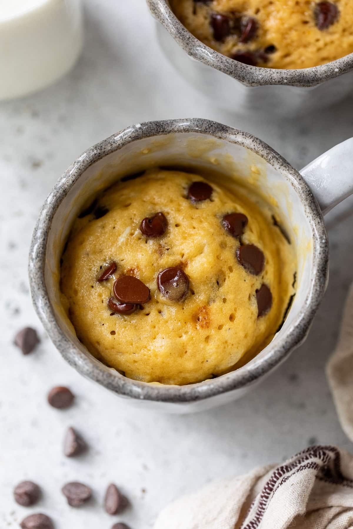 overhead view of a cooked chocolate chip mug cake in a mug.