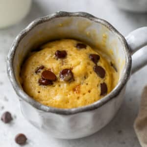 side view of a cooked chocolate chip mug cake in a mug.