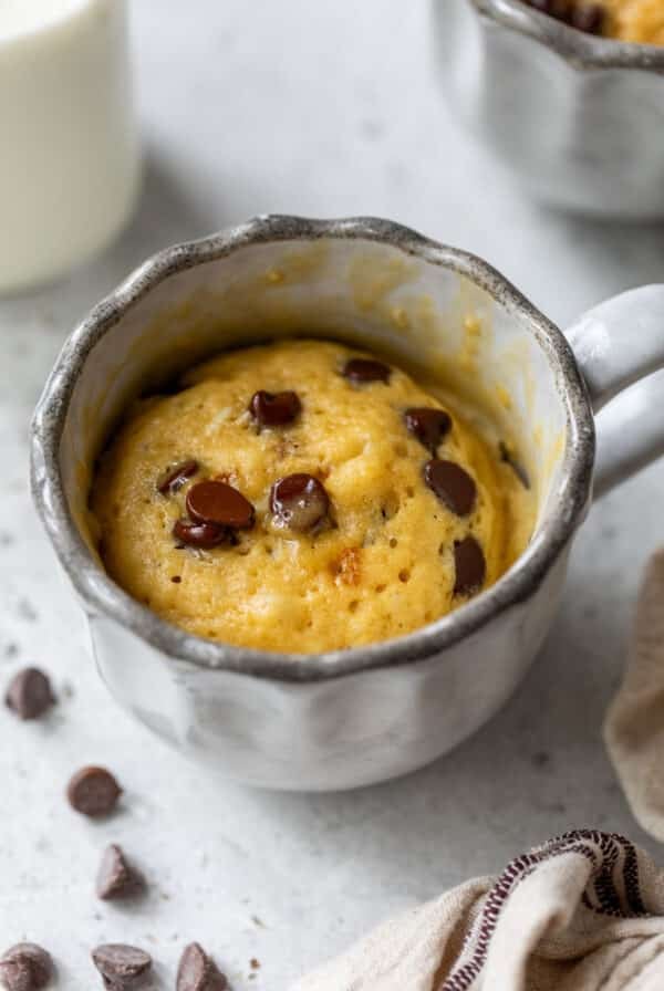 side view of a cooked chocolate chip mug cake in a mug.