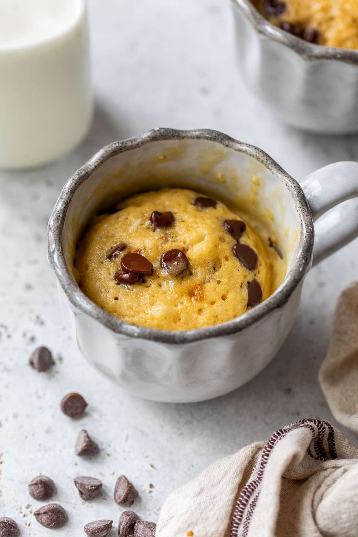 side view of a cooked chocolate chip mug cake in a mug.
