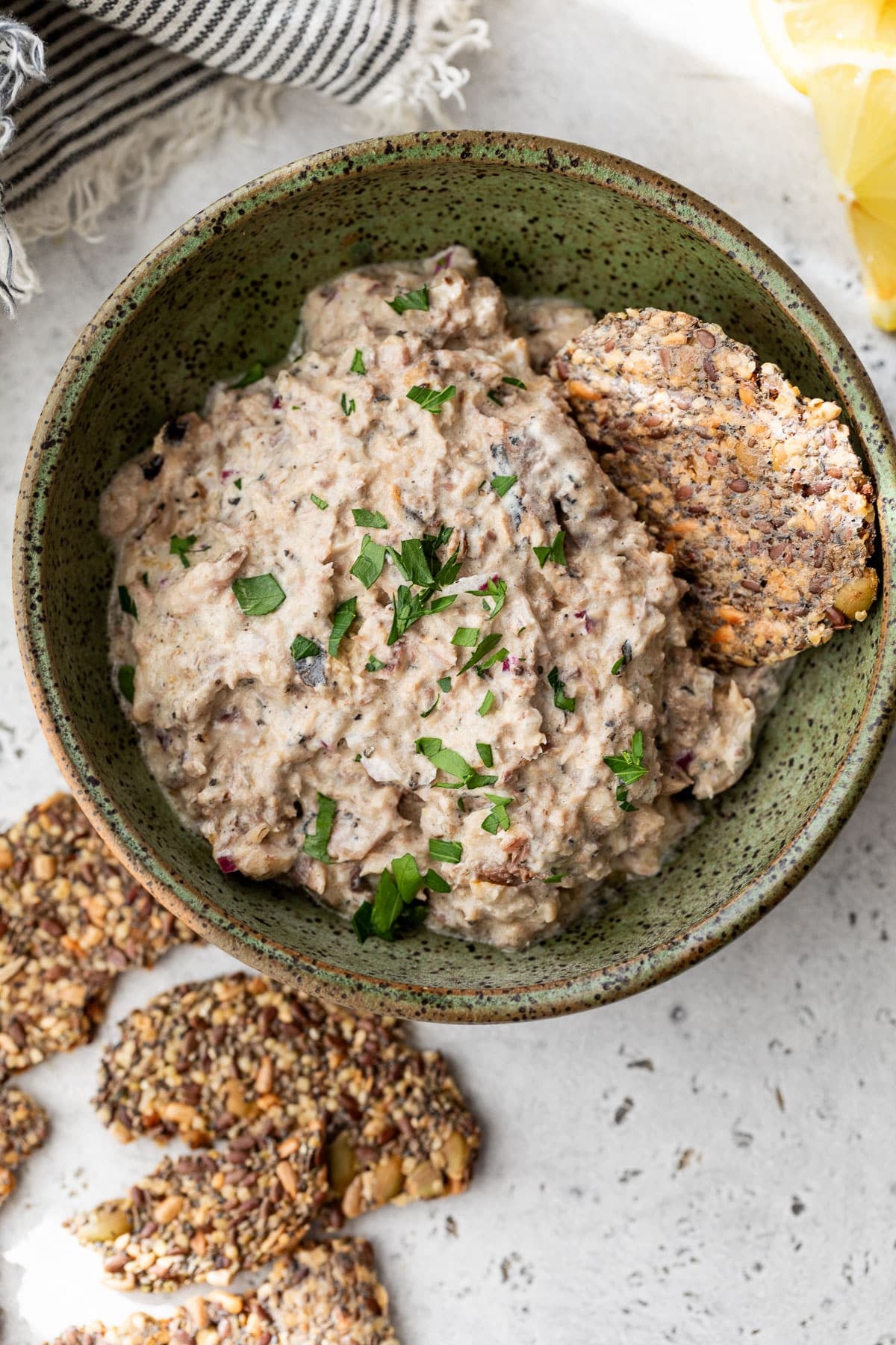 overhead view of a bowl of creamy sardine salad next to crackers.