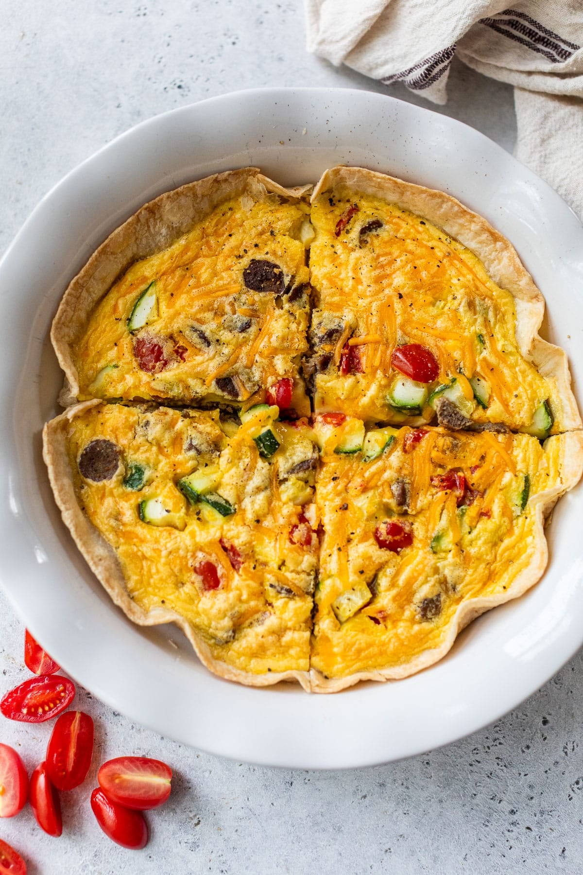 overhead view of a sliced tortilla quiche in a white pie plate.