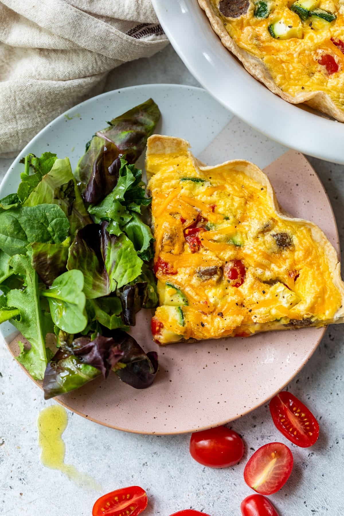 overhead view of a slice of tortilla quiche next to a salad on a plate.