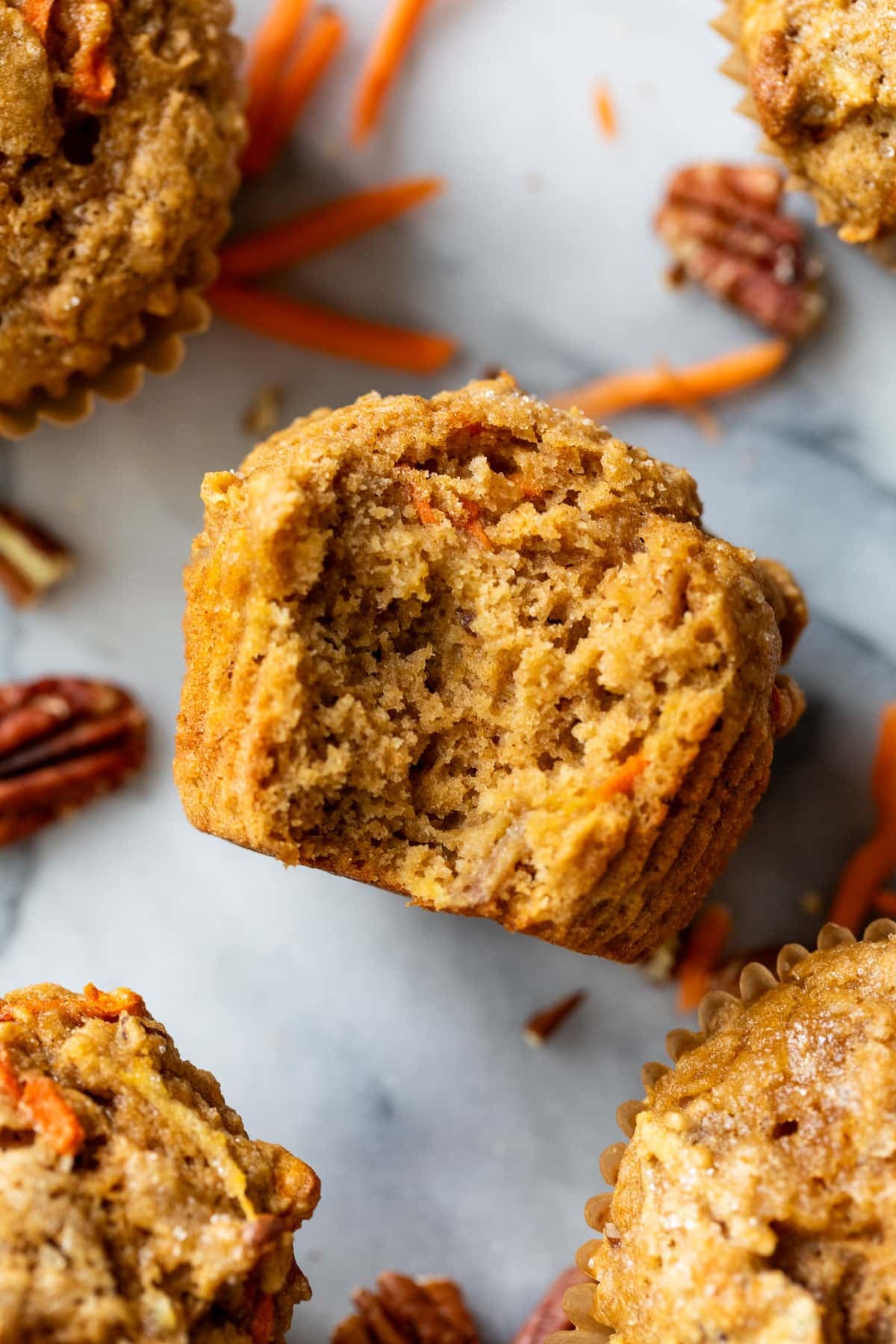 overhead view of an apple carrot muffin with a bite taken out of it.