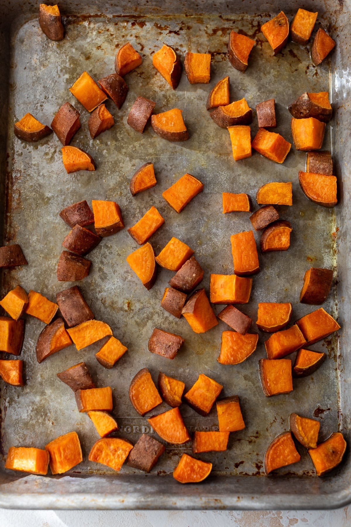 overhead view of roasted sweet potato cubes on a baking sheet.