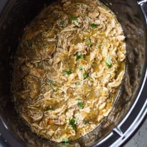 overhead view of shredded salsa verde chicken in a crockpot.
