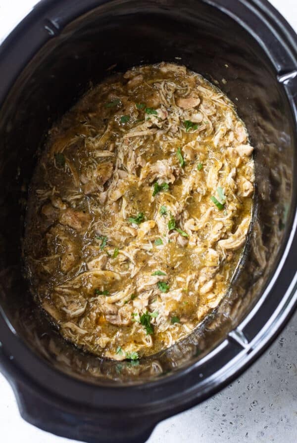 overhead view of shredded salsa verde chicken in a crockpot.