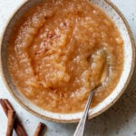 overhead view of a spoon in a bowl of homemade applesauce.