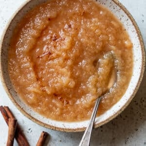 overhead view of a spoon in a bowl of homemade applesauce.