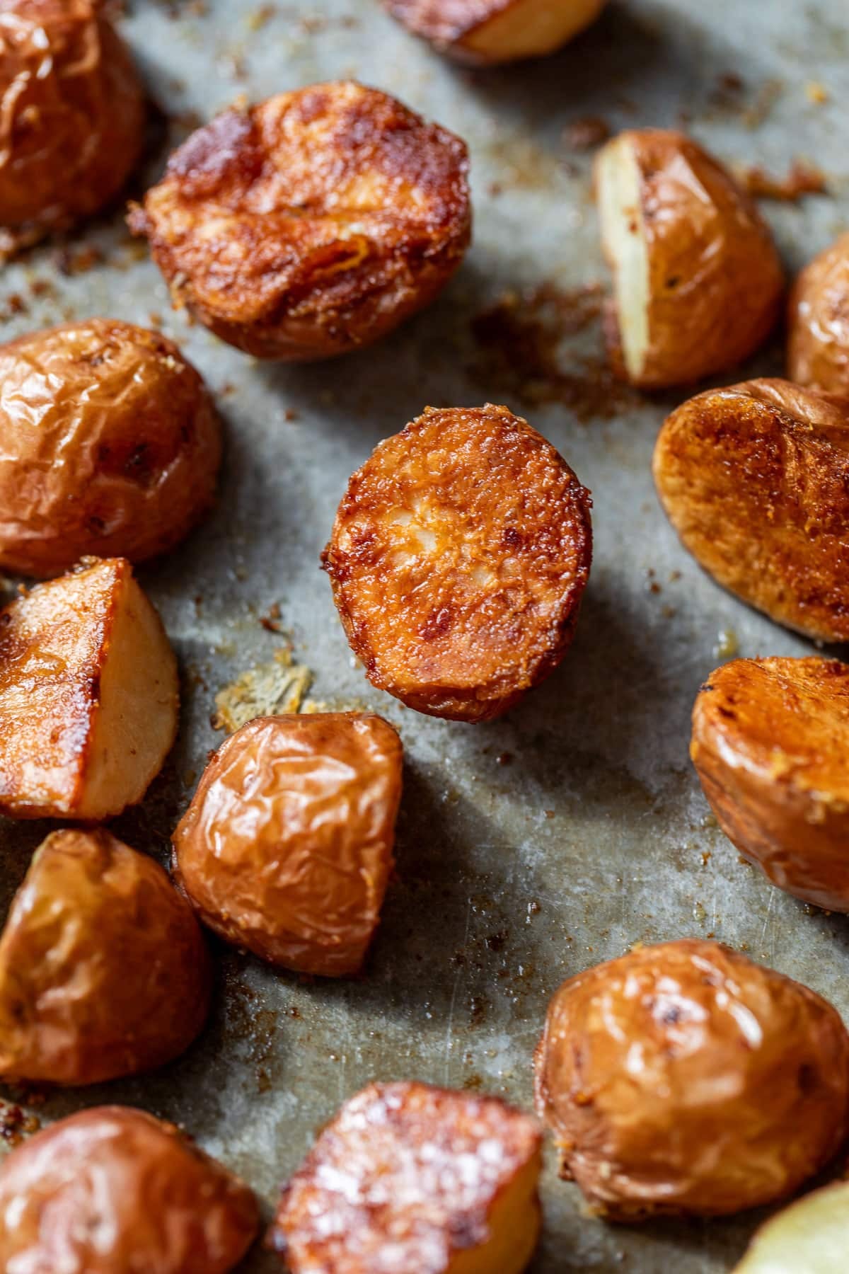 close up on parmesan roasted red potatoes on a baking sheet.