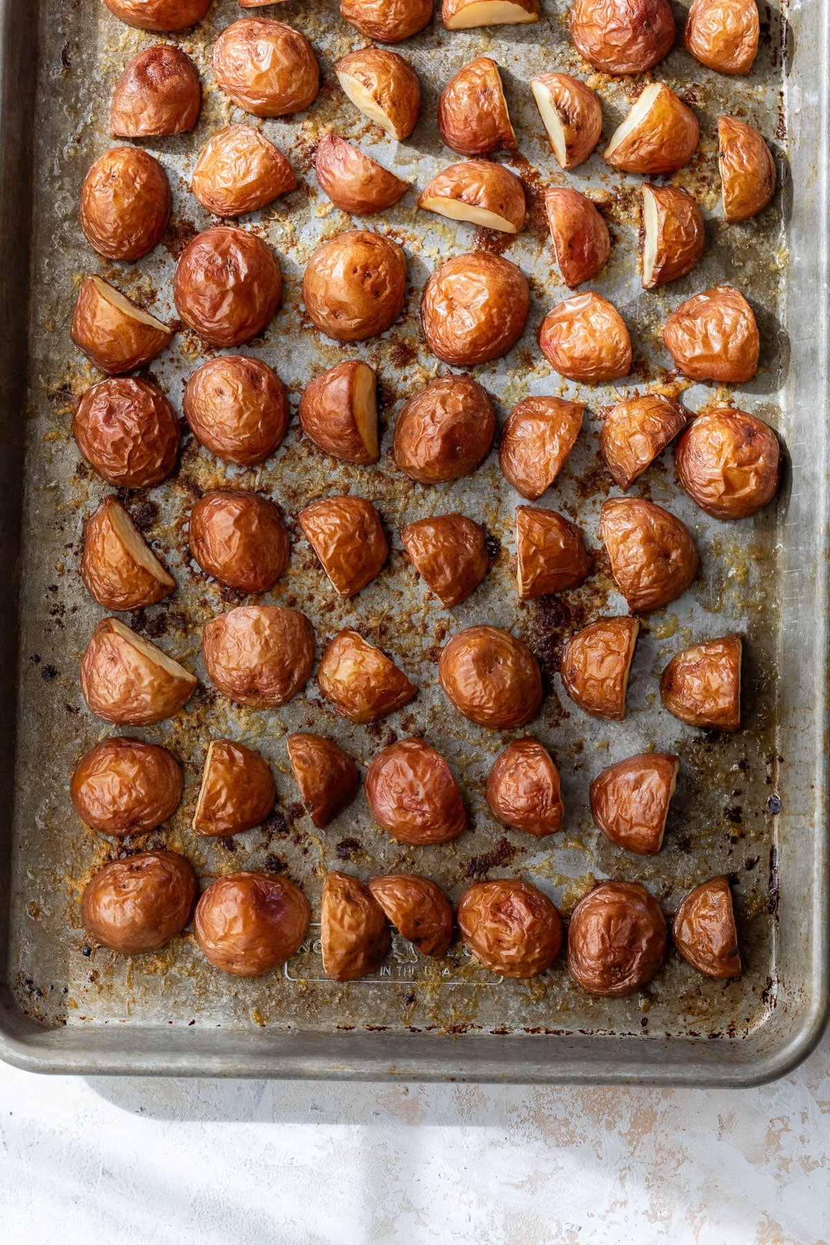 overhead view of parmesan roasted red potatoes on a baking sheet.