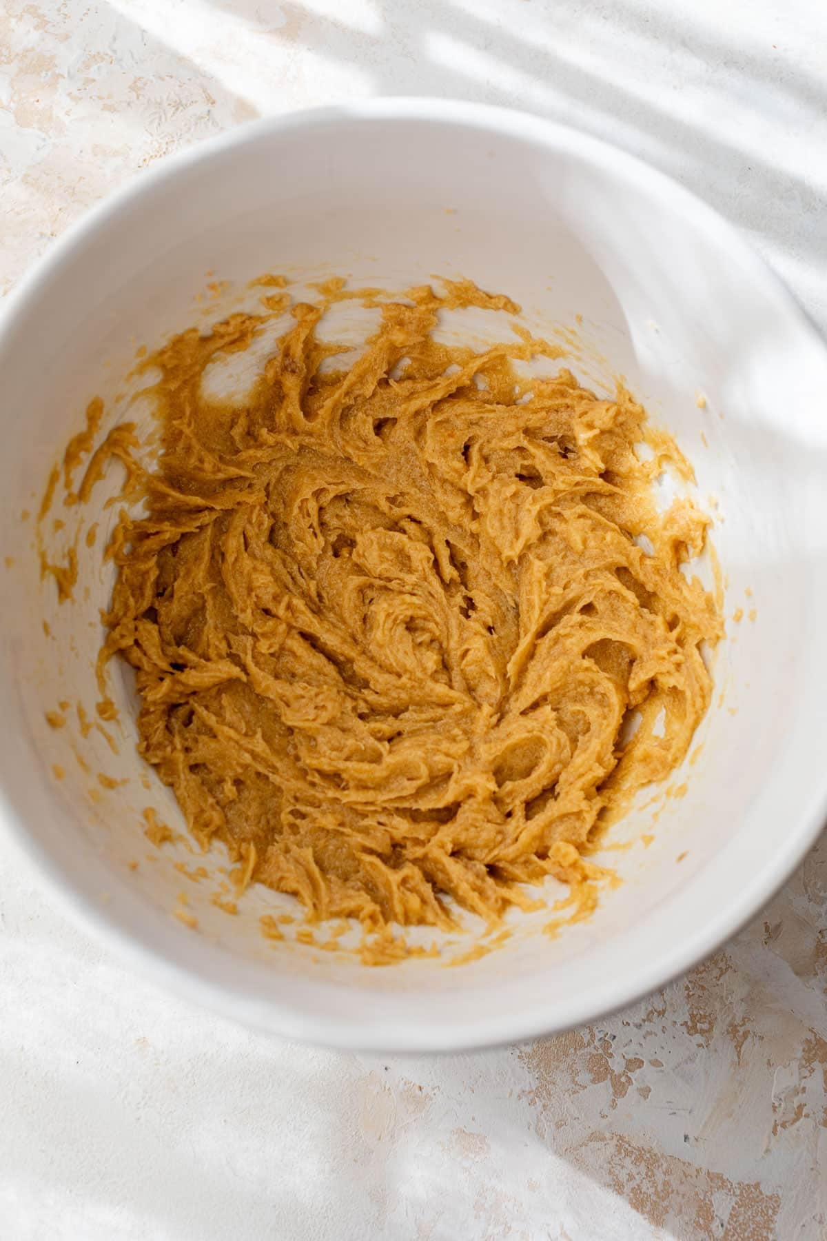 overhead view of wet cookie dough for pistachio cookies in a large bowl.